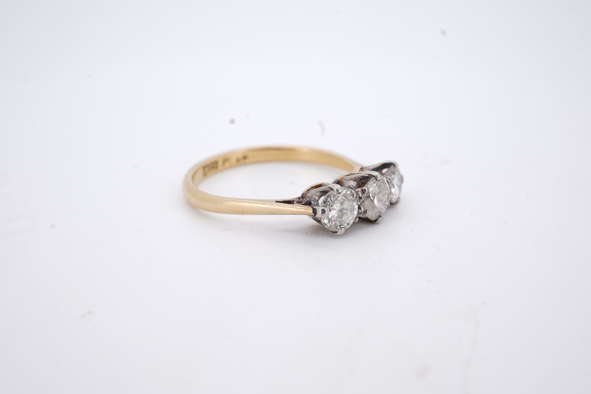 A yellow metal (stamped 18ct, & plat) and three stone diamond set ring, size L, gross weight 2.1 grams.